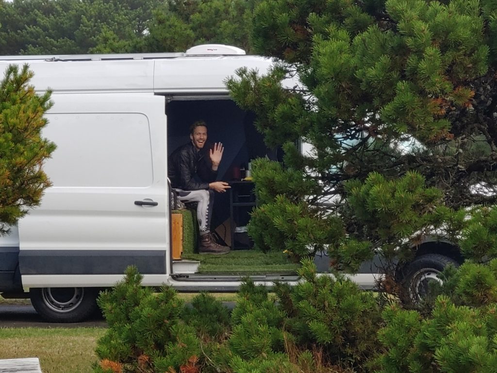 Young man in van waving to his mom in her van at Nehalem State Park in Washington