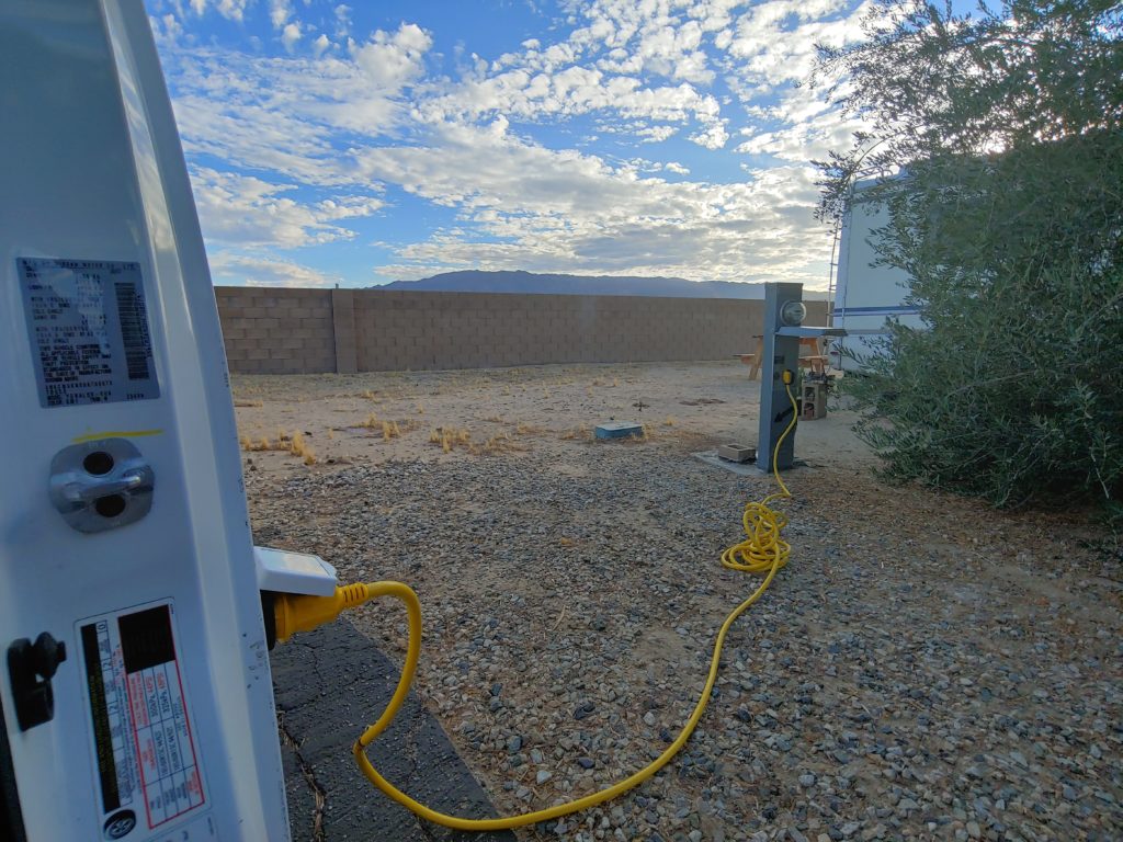 A van hooked up to 30amp shore power at an RV park